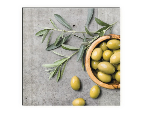 Natură statică cu măsline într-un bol de lemn și ramură de măslin pe fundal de beton