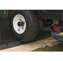 Prim-plan al unei anvelope de tractor de gazon pe un profil de prag