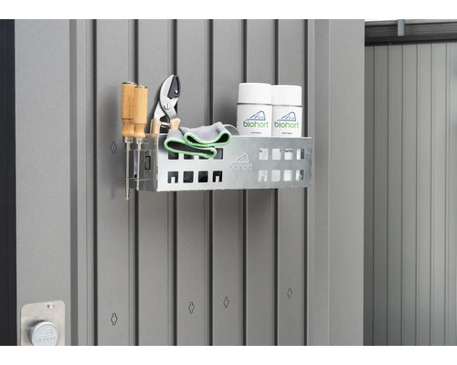 Raft cu unelte de grădinărit și spray-uri pe un perete gri