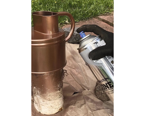 O persoană pulverizează un ulcior cu un recipient cu pulverizator.