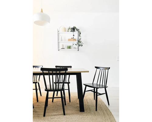 Sufragerie cu masă din lemn, scaune negre și raft de perete