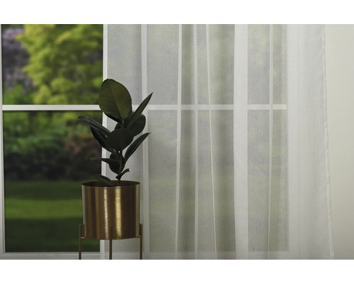 Voal decorativ în fața unei ferestre cu o plantă de apartament în ghiveci