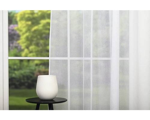 Fereastră decorativă cu perdea și vază pe o masă