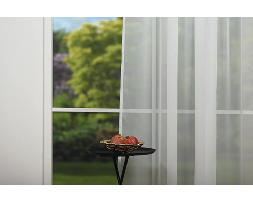 Aranjament decorativ cu perdele, masă și un bol cu fructe în fața ferestrei