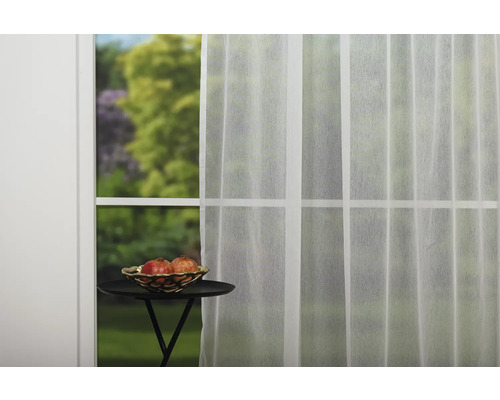 Fereastră cu perdea albă transparentă, masă cu vas cu fructe
