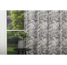 Cortină decorativă cu model floral lângă o masă cu o vază de flori.