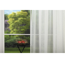Șaluri decorative în fața ferestrei cu un castron cu fructe pe masă