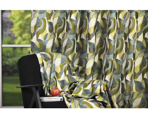 Cortină decorativă cu model abstract lângă un fotoliu.