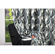 Cortină decorativă cu model abstract lângă o fereastră și un fotoliu.