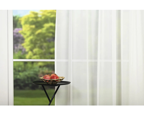 Fereastră cu perdea albă, măsuță laterală și bol cu fructe