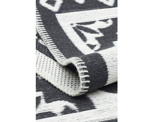 Detaliu al unui covor gri cu model alb