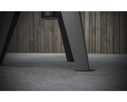 Prim-plan al picioarelor unei piese de mobilier pe un fundal gri