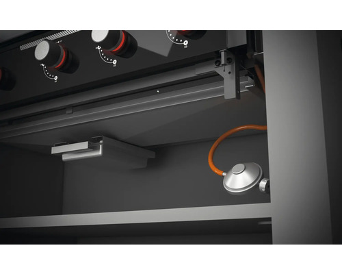 Vedere interioară a unui grătar pe gaz cu elemente de control și conexiune la gaz