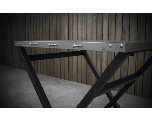 Imagine detaliată a unei mese pliante cu cadru metalic și cârlige