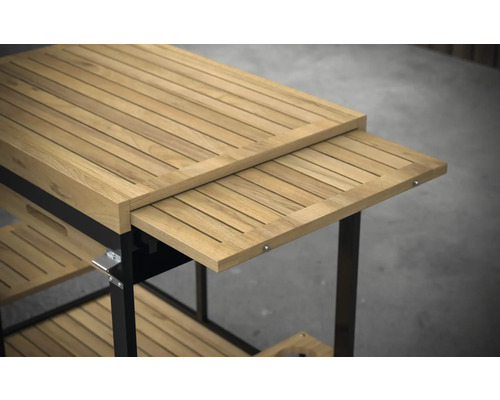 Imagine detaliată a unui cărucior de servire din lemn de tec cu blat extensibil și spații de depozitare.