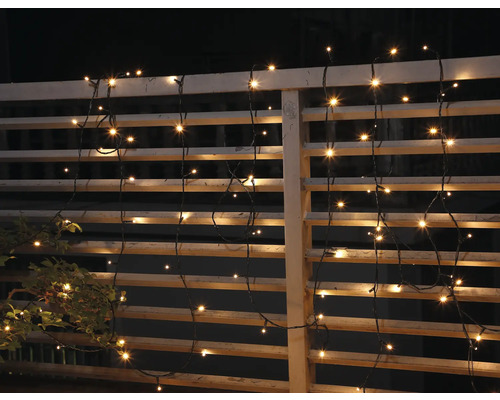 Șir decorativ de lumini atașat unui gard