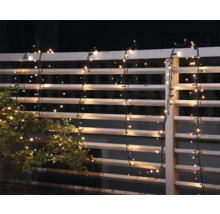 Ghirlandă luminoasă decorativă pe un gard de grădină