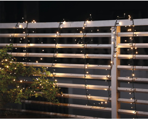 Ghirlandă luminoasă decorativă pe un gard de grădină