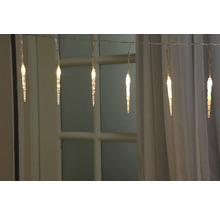 Ghirlandă luminoasă țurțuri în fața unei ferestre