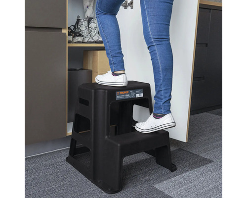 Persoană urcând pe o scară neagră cu două trepte.