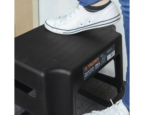 Taburet negru din plastic cu o persoană pe el