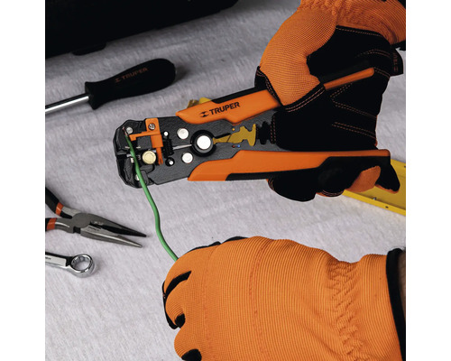 Persoană cu mănuși care folosește un clește de dezizolat Truper pentru a dezizola un cablu.