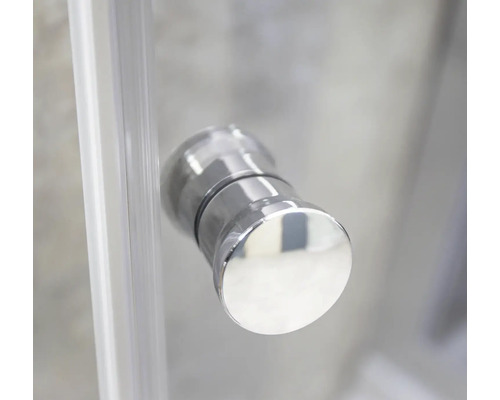 Prim-plan al unui buton de ușă rotund, argintiu, pe o cabină de duș