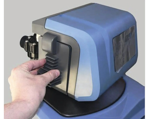 Prim-plan cu un dedurizator de apă cu o mână care instalează un filtru