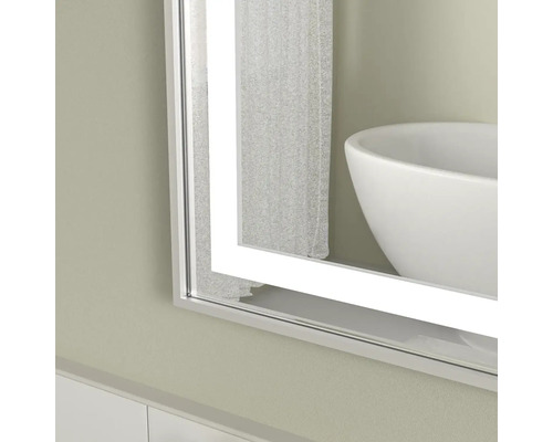 Oglindă de baie iluminată cu chiuvetă în fundal