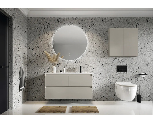 Baie modernă cu lavoar, oglindă iluminată, dulap suspendat și toaletă în fața unui perete cu model de piatră