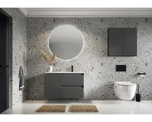 Baie modernă cu dulap sub lavoar, dulap cu oglindă și WC suspendat în fața unui perete cu model