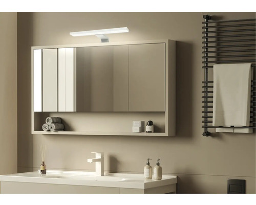 Baie modernă cu dulap cu oglindă, lavoar, calorifer pentru prosoape și design minimalist