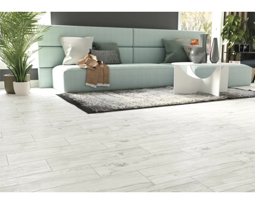 Cameră de zi luminoasă cu canapea, covor și podea din lemn deschis la culoare