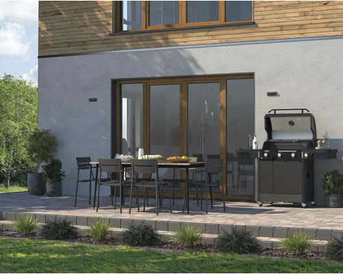 Terasa cu grătar și zonă de relaxare în fața fațadei casei