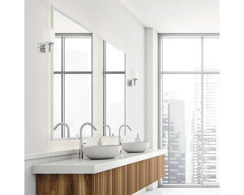 Baie modernă cu lavoar, lavoar pe blat, oglindă și fațadă de sticlă.