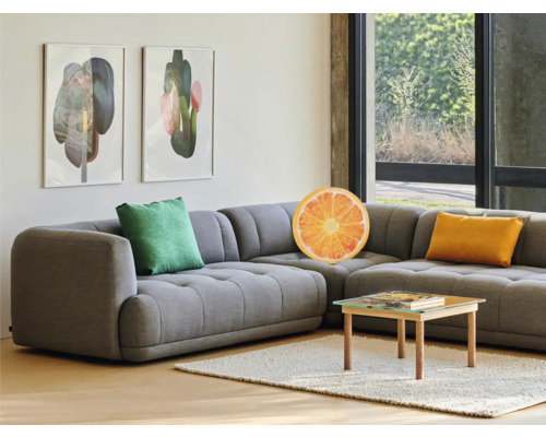 Cameră de zi cu canapea de colț gri, perne și măsuță de cafea