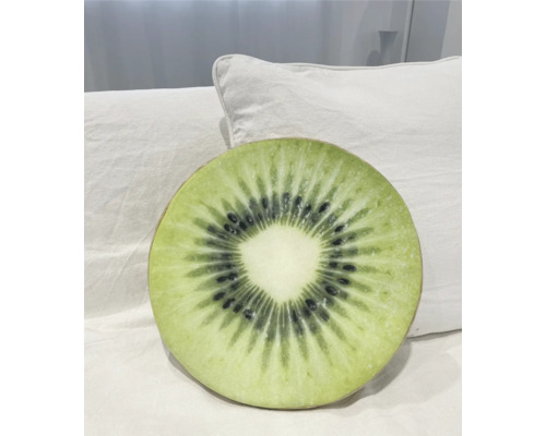 Pernă rotundă cu design de kiwi pe o pernă albă