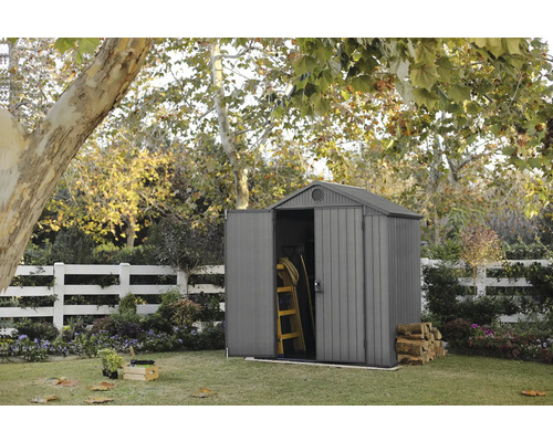 Scenă de grădină cu șopron, scară și lemne de foc în grădină