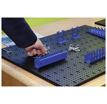 Panou negru perforat cu suporturi albastre și cârlige argintii pentru depozitarea sculelor