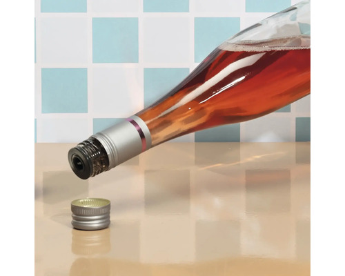 O sticlă deschisă de vin rose cu capac cu filet stă pe masă.