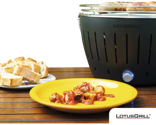 Grătar LotusGrill cu cârnați, currywurst și pâine pe o masă de lemn