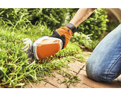 Foarfecă de iarbă cu acumulator utilizată pentru tunderea marginilor gazonului.