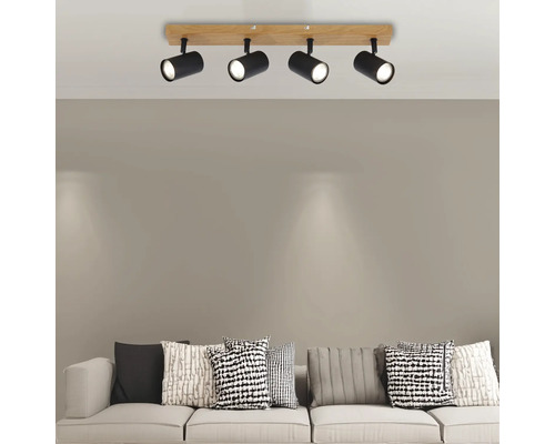 Lumină de plafon cu patru spoturi din lemn și metal deasupra unei canapele