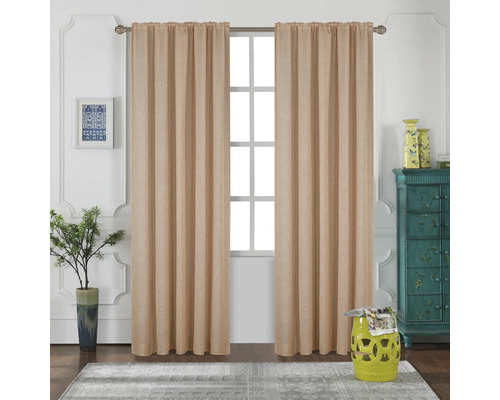 Scenă cu perdele bej în fața unei ferestre, completată de elemente decorative, precum o măsuță laterală, o comodă și plante de interior.