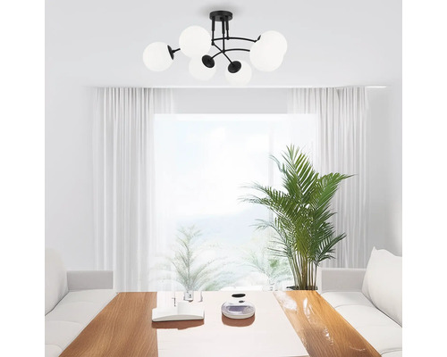 Plafoniere neagră cu cinci abajururi rotunde din sticlă într-o cameră luminoasă