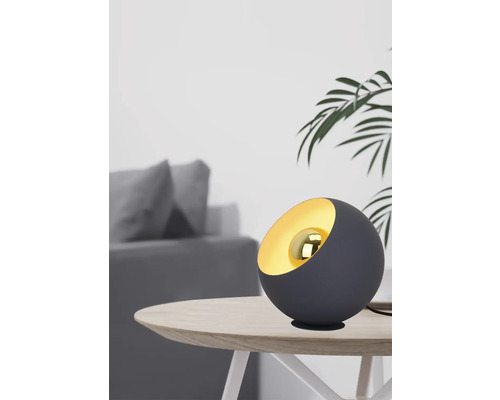 Lampă de masă decorativă pe o masă cu un interior modern în fundal