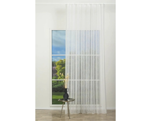 Fereastră cu perdea albă și măsuță laterală cu decorațiuni