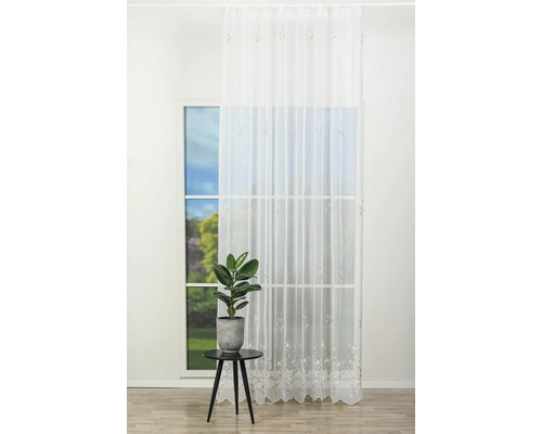 Scenă de fereastră cu șal decorativ transparent și plantă de interior pe o măsuță