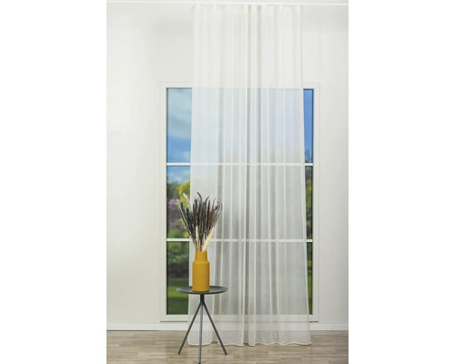 Cameră luminoasă cu fereastră, perdea deschisă la culoare și măsuță laterală cu decorațiuni