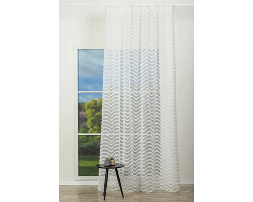 Cortină decorativă, transparentă, cu model ondulat în fața unei ferestre.